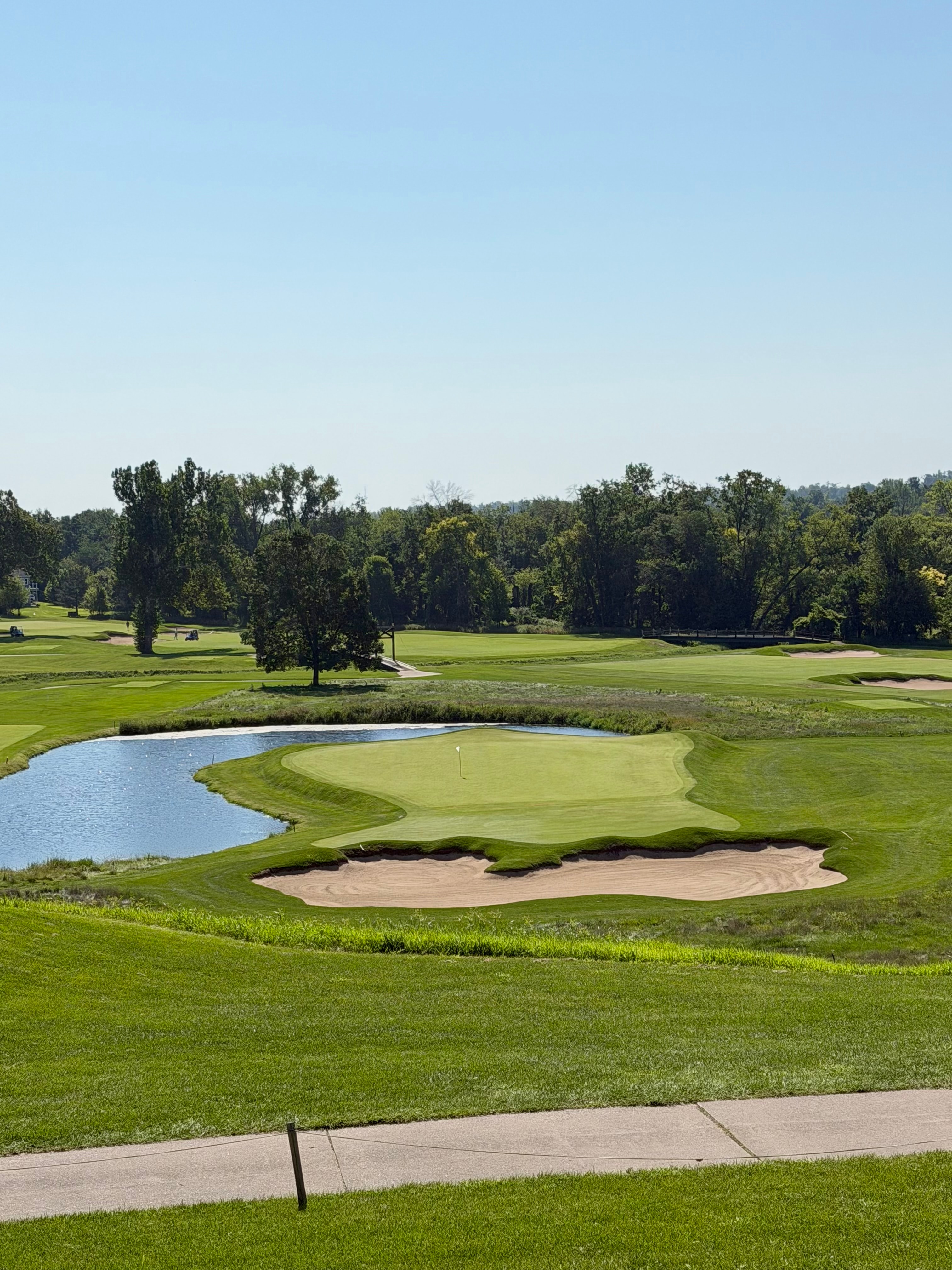 The downhill eighth green at Cedar Rapids Country Club with water left and a bunker in front